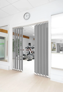 Vertikaljalousien in heller Fitnessumgebung mit Glastür